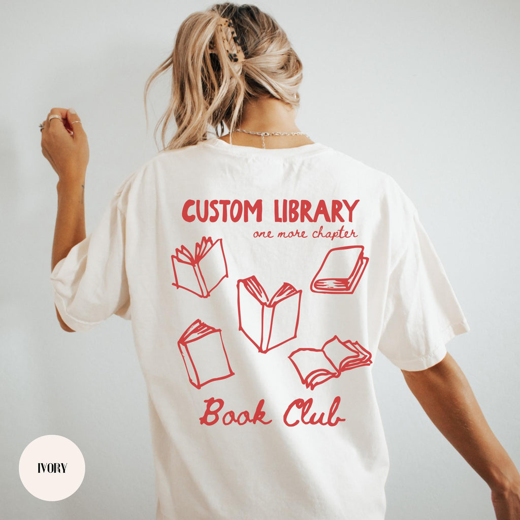 Woman wearing a white custom book club shirt with a red personalized library name, BOOK CLUB lettering and open-book back print.