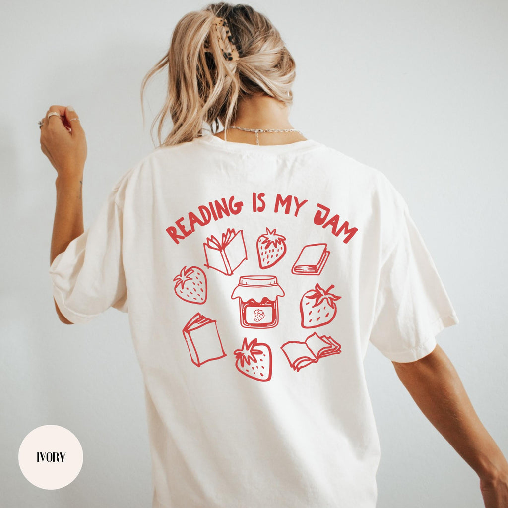 Book lover shirt mockup showing a bold back print that reads Reading Is My Jam, offered on Comfort Colors tees and Gildan sweatshirts.