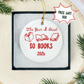 White round porcelain Christmas ornament displayed in a black gift box, featuring red open books and customizable text The Year I Read 50 Books 2026.